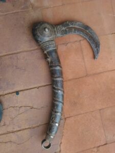 Un couteau de récolte en fer, illustrant l'artisanat traditionnel africain.