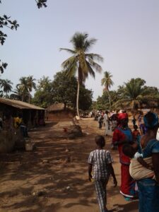 Ruelle animée d\'un village en afrique pittoresque, avec des habitants et des visiteurs profitant de l\'ambiance conviviale.