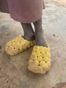 Pieds d\'un enfant africain, montrant la texture de la peau et le sol poussiéreux.