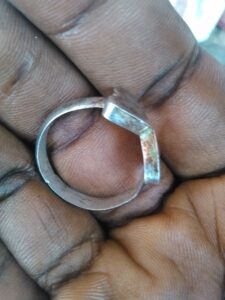 Image d'une main tenant une bague en argent, mettant en valeur l'accessoire.
