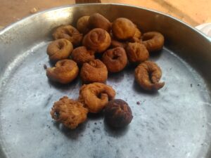 Un plateau rempli de beignets africains, dorés et gonflés, parfaits pour une collation savoureuse.