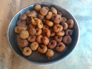 Un plateau de beignets africains, parfaitement dorés et gonflés, avec une texture légère et moelleuse.