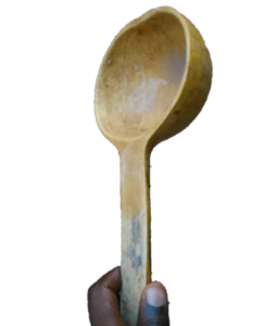 Cuillère traditionnelle en bois utilisée avec une calebasse pour servir ou manger des aliments.