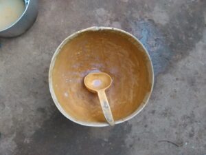 Une cuillère en calebasse posée à l'intérieur d'une calebasse, illustrant un artisanat authentique d'Afrique
