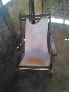 Chaise pliante traditionnelle en Afrique, souvent utilisée pour s'asseoir lors de rassemblements ou d'événements.