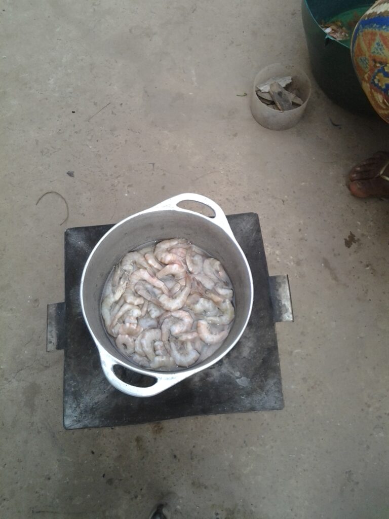 Des crevettes fraîches en train de cuire dans une marmite sur le feu.