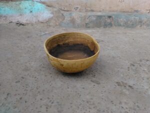 Une calebasse posée sur le sol, un objet culturel et utilitaire couramment utilisé en Afrique.