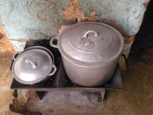 Deux marmites posées sur des fourneaux en Afrique, utilisées pour cuire des repas en grande quantité.