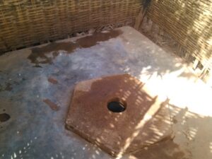 Toilette africaine traditionnelle dans un village, souvent construite avec des matériaux locaux tels que le bambou ou la terre.