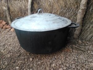Grande marmite fermée, utilisée pour cuisiner des repas en grande quantité dans un village africain.