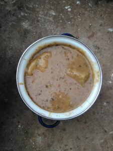 le tô Un plat traditionnel africain composé de mets variés, tels que du riz, des légumes, de la viande et des épices, joliment disposés dans un grand plat.