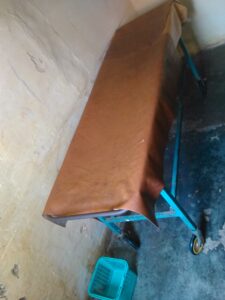 Lit de patient dans un hôpital en Afrique, avec des draps simples et un environnement médical de base.