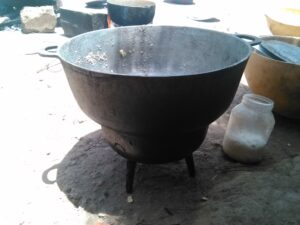Grande marmite en métal, utilisée pour cuisiner de grands repas dans un village africain.