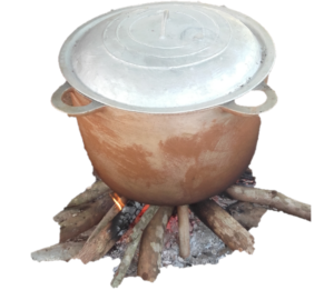 Une grande marmite posée sur un feu de bois, en train de cuire un plat traditionnel africain sur un foyer extérieur.