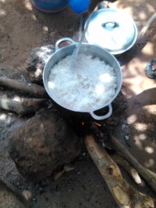 Du riz dans une marmite en métal, en train de cuire sur un feu de bois, une méthode traditionnelle de cuisson en Afrique