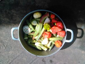 Des marmites pleines de légumes frais non découpés, typiques de la cuisine traditionnelle africaine.