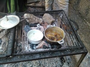 "Deux petites marmites sur un feu, avec des fillettes apprenant à cuisiner ensemble."