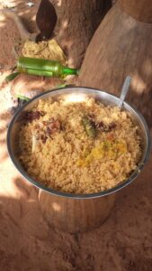 Un grand plat de riz, typique de la cuisine africaine, prêt à être partagé lors d'un repas traditionnel.