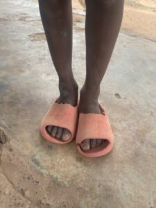Pieds nus d’un petit garçon africain sur un sol en terre