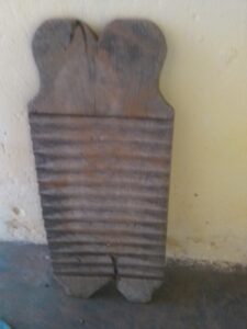Planche artisanale en bois utilisée pour laver les habits à la main dans un village africain.