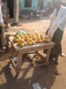 Table de marché avec des mangues fraîches empilées en tas, prêtes à être vendues.