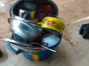 Une grande bassine contenant divers ustensiles de cuisine traditionnels, typique d'une cuisine africaine.