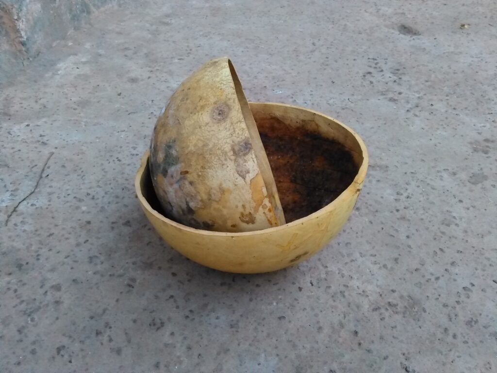 Une calebasse traditionnelle posée sur le sol.
