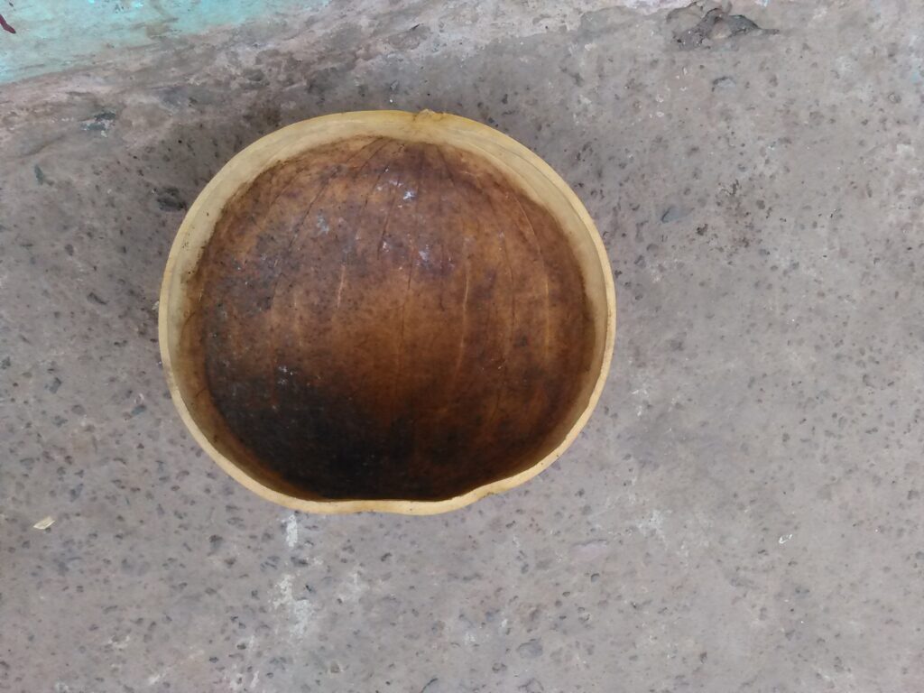 Une calebasse traditionnelle posée sur le sol.