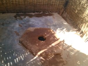 Structure de douche rudimentaire ou simple dans un environnement rural africain.