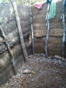 Structure complète de douche extérieure construite en paille dans un village africain.