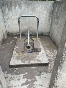 Pompe à eau manuelle à côté d'un forage dans un environnement rural africain. (Si l'image montre la pompe)
