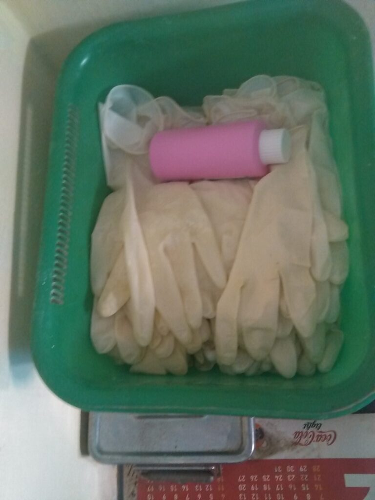 Image de gants d'hygiène en plastique, potentiellement portés ou dans un emballage, utilisés pour des soins médicaux en Afrique