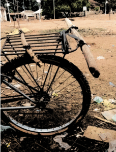Image d'un vélo stationné ou en mouvement dans un village africain traditionnel