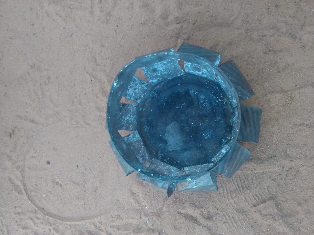 Un petit fourneau ou réchaud en métal, utilisé pour faire chauffer de l'eau et préparer le thé, posé sur une surface en terre ou en pierre.