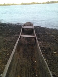 Pirogue en bois attachée et laissée à l’abandon au bord d’un fleuve africain, près d’un village