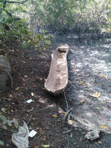 Pirogue en bois attachée et laissée à l’abandon au bord d’un fleuve africain, près d’un village