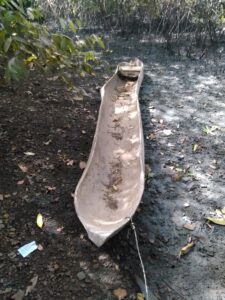 Pirogue en bois attachée au bord d’un fleuve africain, abandonnée près d’un village