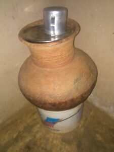Canari africain sculpté à la main, conçu pour conserver de l'eau, orné de motifs traditionnels africains.