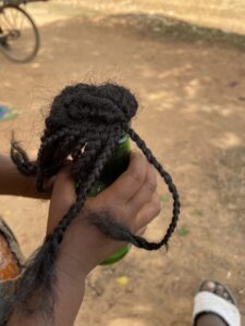 Poupée artisanale en bouteille avec des cheveux afro et des vêtements traditionnels africains.