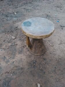 Un petit tabouret en bois, simple et traditionnel, évoquant le mobilier rural authentique.